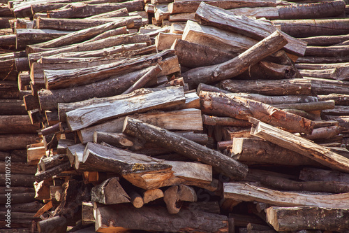 Wooden natural cut logs laying horizontal texture, background backdrop side view, flat lay. Lumber, timber, firewood storage. Woodpile, long cut, forestry, deforestation concept. Sepia, warm color