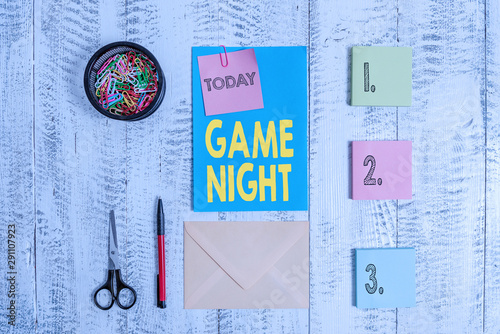 Word writing text Game Night. Business photo showcasing event in which folks get together for the purpose of getting laid Envelope letter sticky note ballpoint clips can scissors wooden background photo