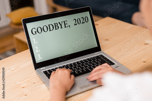 Word writing text Goodbye 2020. Business photo showcasing New Year Eve Milestone Last Month Celebration Transition woman laptop computer smartphone mug office supplies technological devices photo