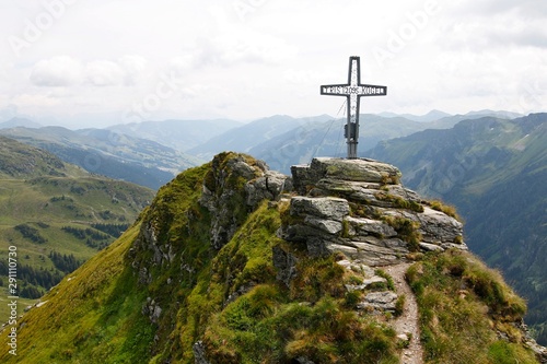 Cross at the top of Tristkogel mountain in Austria during summer