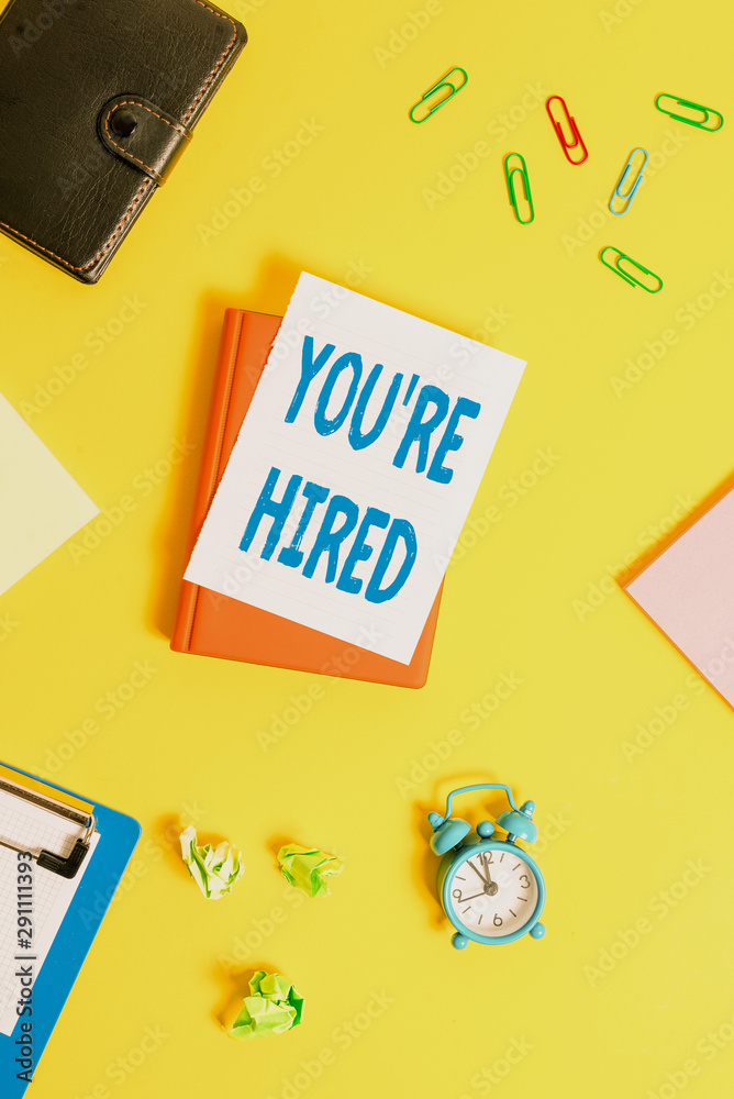 Text sign showing You Re Hired. Business photo showcasing New Job Employed Newbie Enlisted Accepted Recruited Pile of empty papers with copy space on the table Text sign showing You Re Hired. Business photo showcasing New Job Employed Newbie Enlisted Accepted Recruited Pile of empty papers with copy space on the table