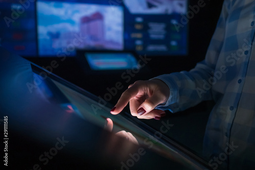 Woman using interactive touchscreen display of electronic multimedia terminal at modern museum or exhibition. Education, futuristic and technology concept