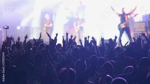 Crowd of fans are cheering at open-air rock concert