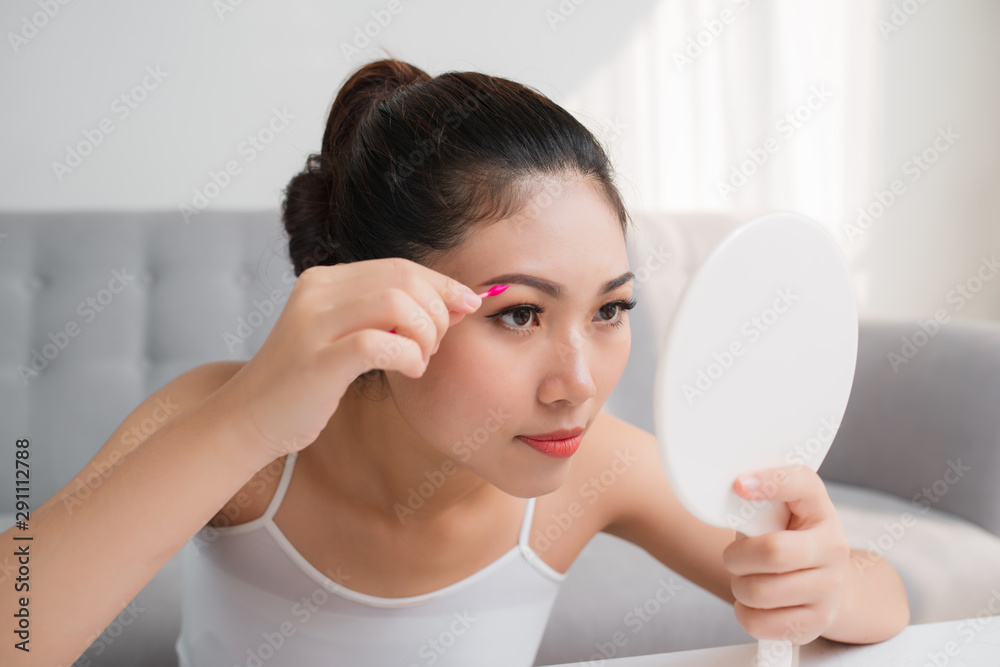 Beautiful Asian woman with a cotton swab beside a her eye. Make up concept. Beautiful Asian woman with a cotton swab beside a her eye. Make up concept.
