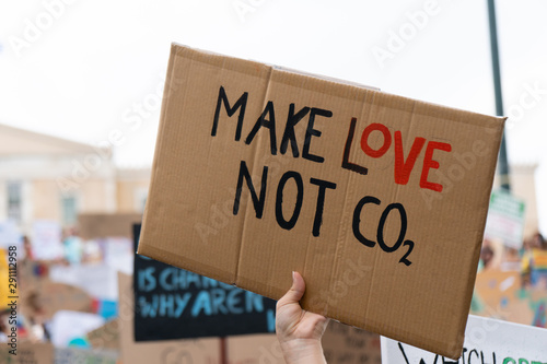 A hand holding a sign protesting the CO2 emissions photo