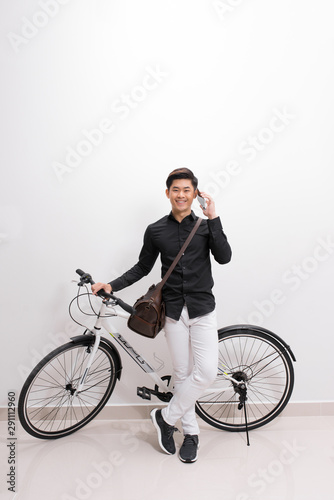Portrait of a handsome man with bicycle in isolation