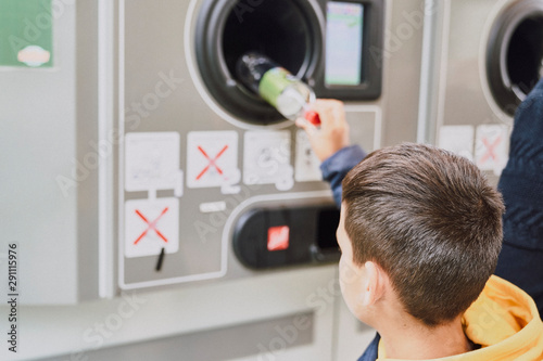 Child recycling plastic bottles in a machine