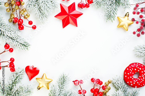 Christmas background. Xmas composition border with snowy fir branch, red holly berries, gold stars and baubles. Xmas flat lay top view with copy space