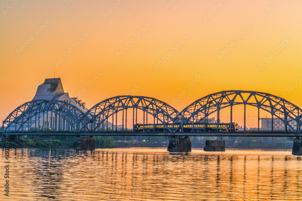 Fototapeta premium Train passing by on the railroad bridge in the city centre 