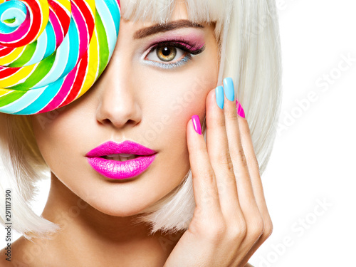 Face of a beautiful  girl with pink eye make-up and multicolor nails. Sweet candy.