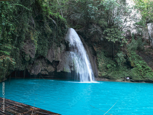 Waterfall with bamboo raft on the turquoise water pool at Kawasan Falls in Cebu Island  Philippines