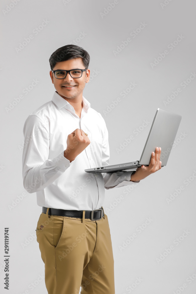 Happy handsome Indian man with laptop great news, screaming in joy because of victorious achievement. Successful deal, business success concept Happy handsome Indian man with laptop great news, screaming in joy because of victorious achievement. Successful deal, business success concept