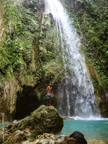 Epic man alone in deep forest waterfall from mountain gorge at hidden tropical jungle in Cebu Island in Philippines