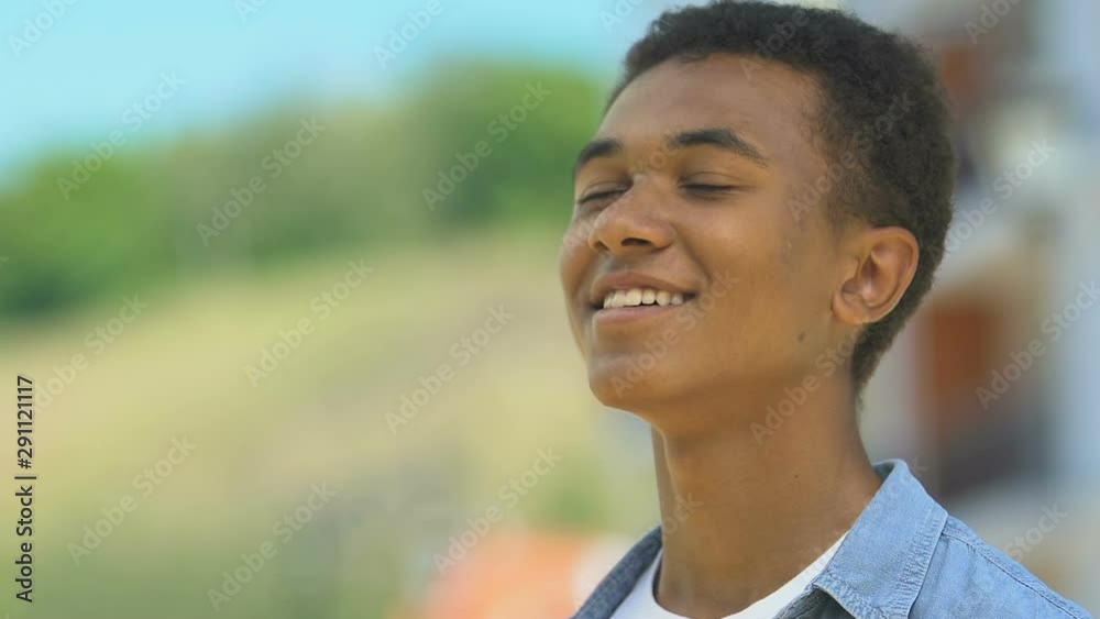 Happy african-american boy breathing enjoying fresh air, outdoor walk closeup Happy african-american boy breathing enjoying fresh air, outdoor walk closeup