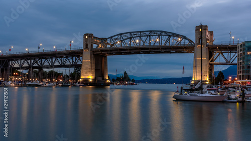 Burrard Bridge, Vancouver, Canada, at dusk, with the lights of the bridge reflecting in the water