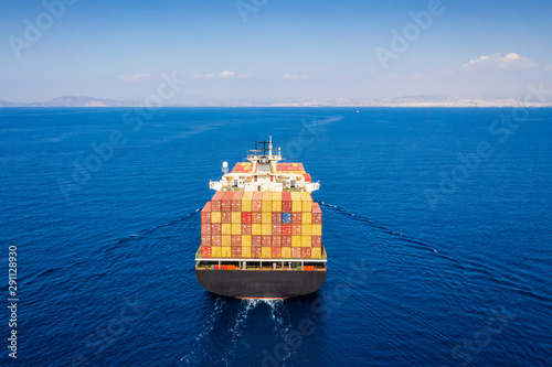 Luftaufnahme eines mit Containern beladenen Frachtschiffs bei Fahrt über blauem Ozean