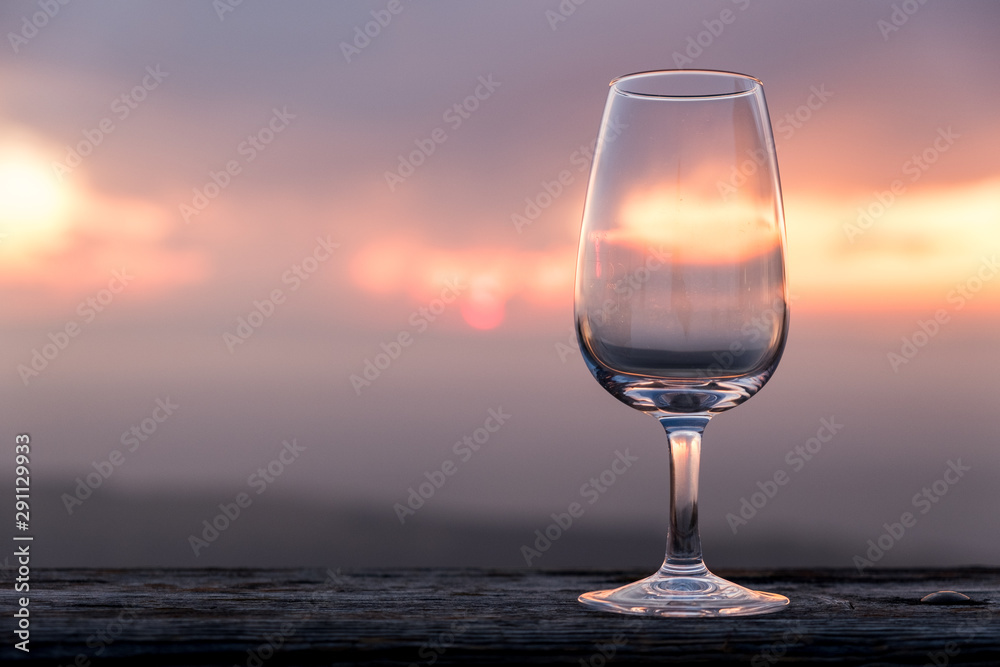 Empty glass of wine in front of a beautiful sunset