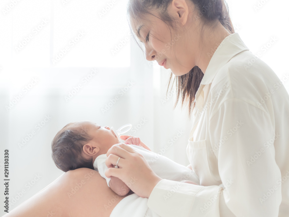 A beautiful Asian woman puts her newborn baby on her body
