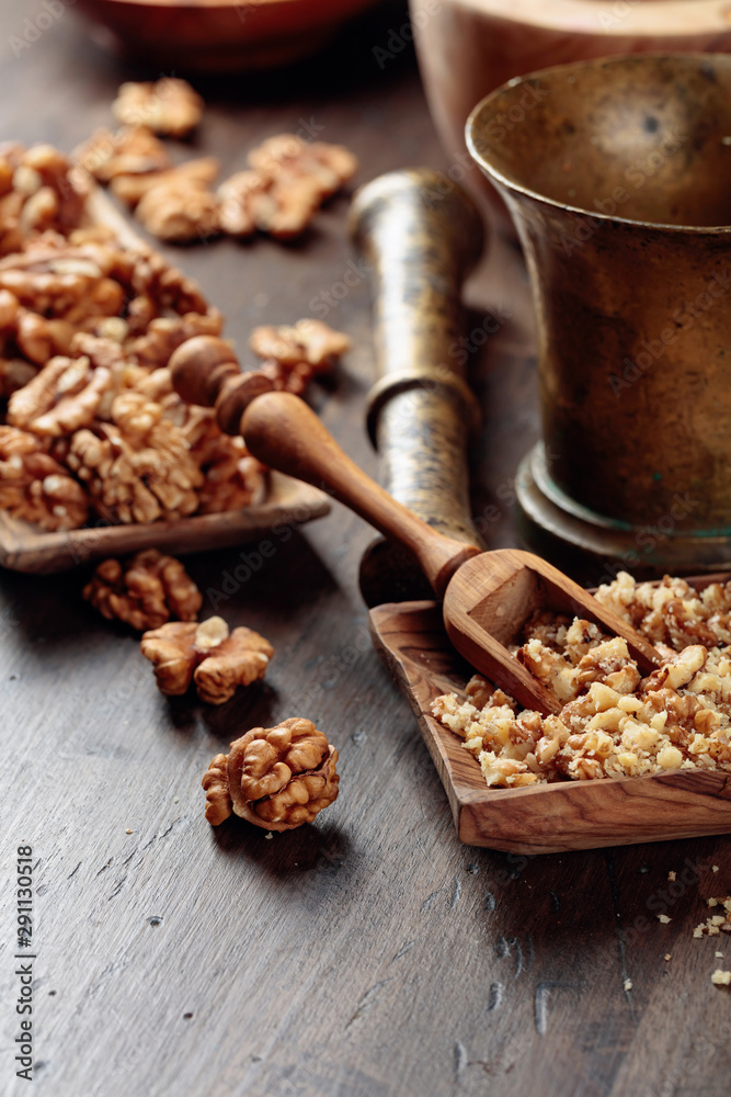 Obraz premium Walnuts in a wooden dish on an old wooden table.