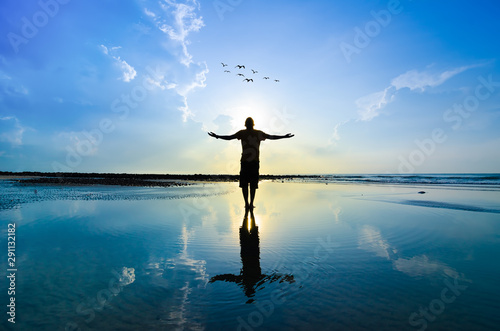 Silhouette of Man Raising His Hands or Open arms when sun rising up