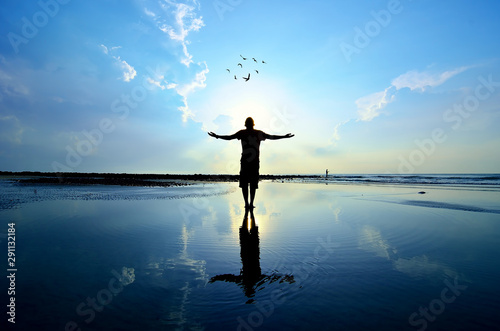 Silhouette of Man Raising His Hands or Open arms when sun rising up photo