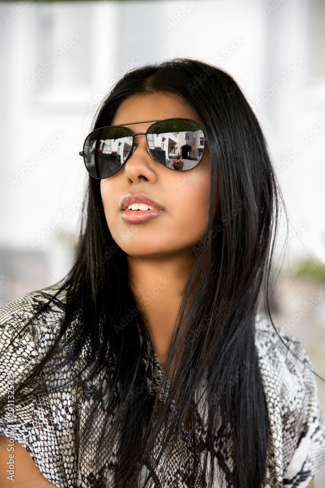 Fashion portrait of an indian stylish woman in sunglasses, long black hair and snake jumpsuit Fashion portrait of an indian stylish woman in sunglasses, long black hair and snake jumpsuit