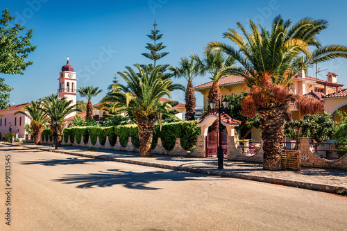 Amazing spring view of the street of Karavomylos village with St. John church on background. Sunny morning scene of Kefalonia island, Greece, Europe. Traveling concept background.