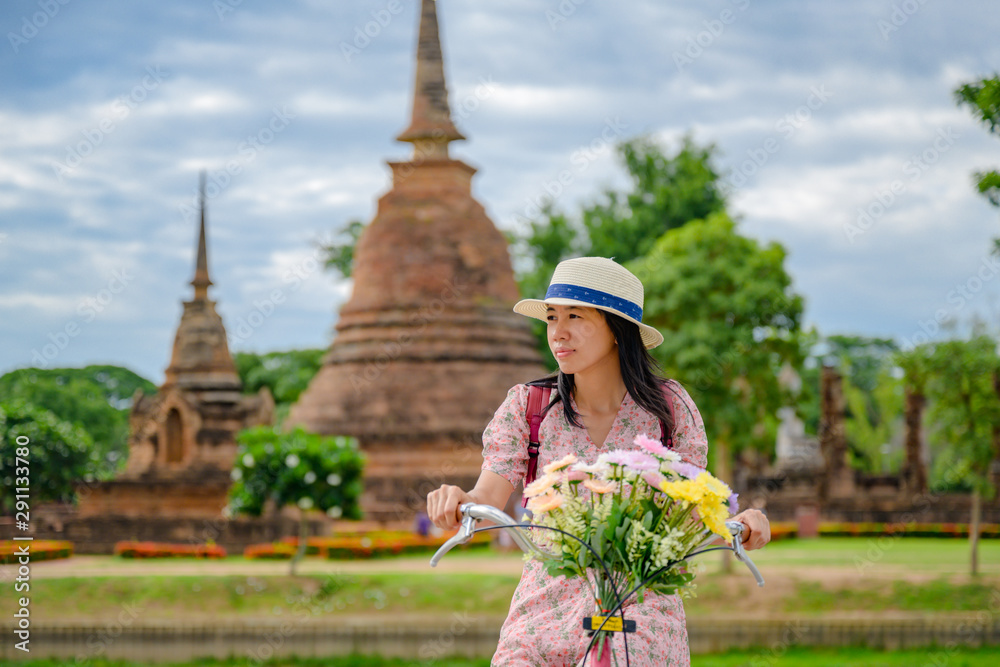 woman tourist enjoy riding local bicycle to see the historic park of Thailand, exciting to explore the wonderful place of sightseeing