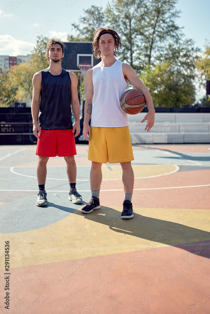Full-length picture of two athletes with basketball on playground . Full-length picture of two athletes with basketball on playground .