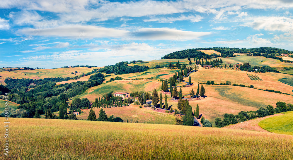 Classic Tuscan view with farmhouse and cypress trees. Colorful summer view of Italian countryside, Val d'Orcia valley, San Quirico d'Orcia location. Beauty of countryside concept background.