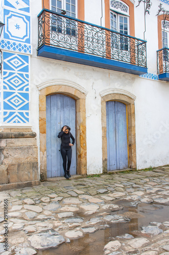 Young teenage girl in black makes pose on the street with interesting scenery © Rogerio