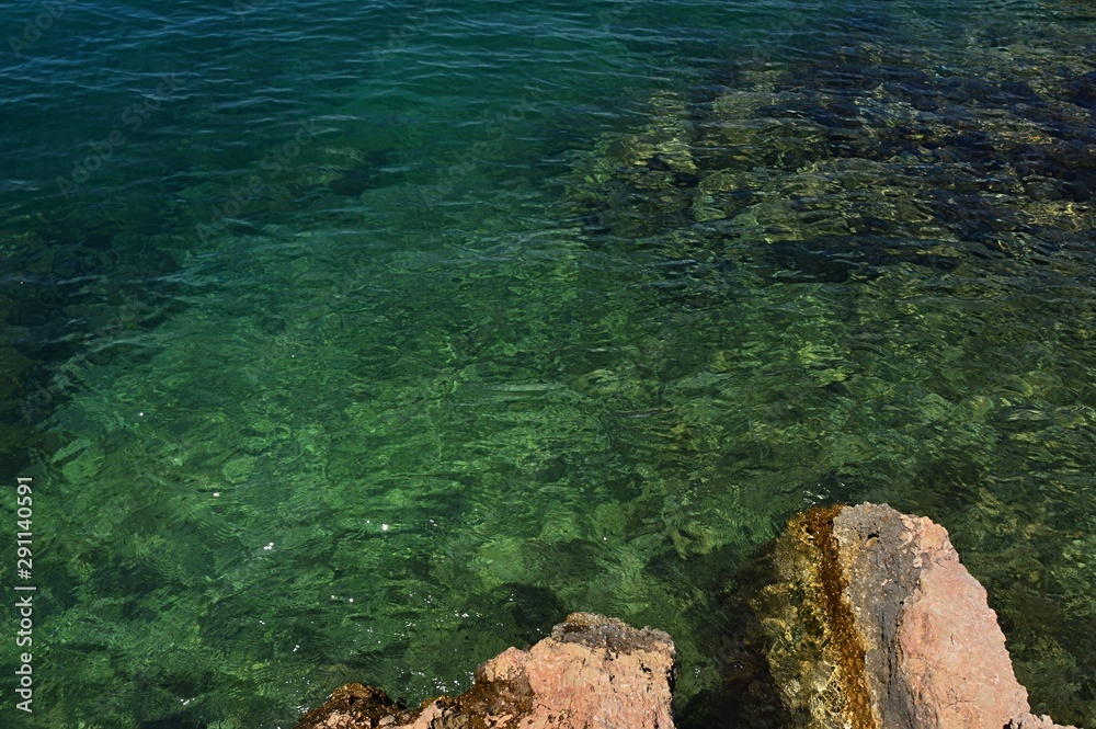Green coloured clean sea water next to rocky shoreline in northern Croatia, Adriatic Sea. 