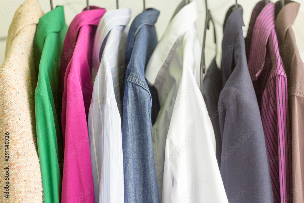 Close - up hangers with different clothes.Shirts and jackets of different colors hanging on a hanger