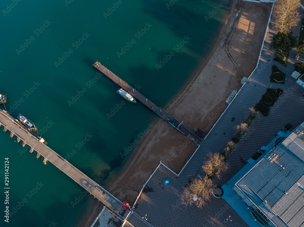 Aerial view of the seashore - turquoise water, piers and boats at the pier