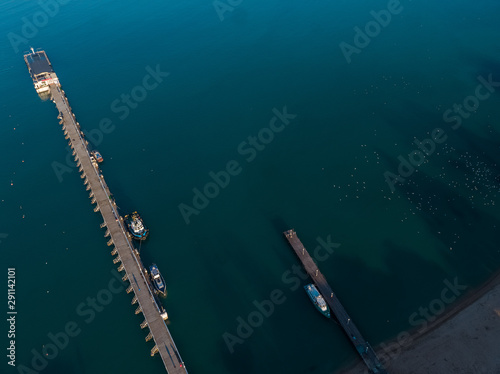 Aerial view of the seashore - turquoise water, piers and boats at the pier