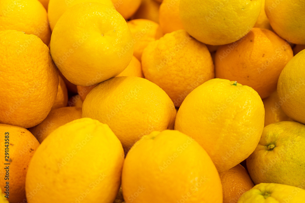 Bright yellow lemons in wooden boxes at farmer's market or grocery store. May be used for background. Aerial view close-up