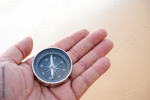 Holding the compass background on the sandy beach