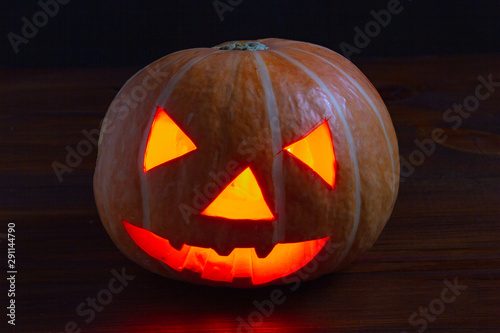 Jack lantern glowing pumpkin for Halloween on dark background