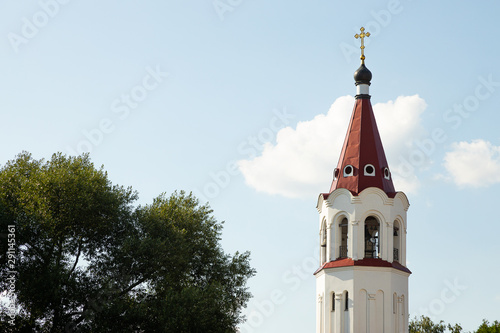 Canvas Print Close-up of maroon top of orthodox church bell tower with cross against sky and