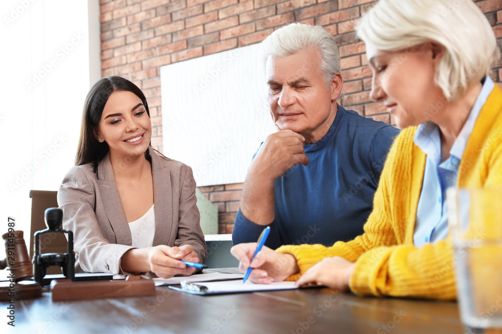 Female notary working with mature couple in office Female notary working with mature couple in office