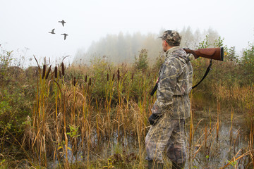 the hunter looks after the departing ducks
