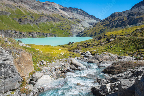picturesque landscape with rapid mountain stream and glacial lake in the Swiss Alps