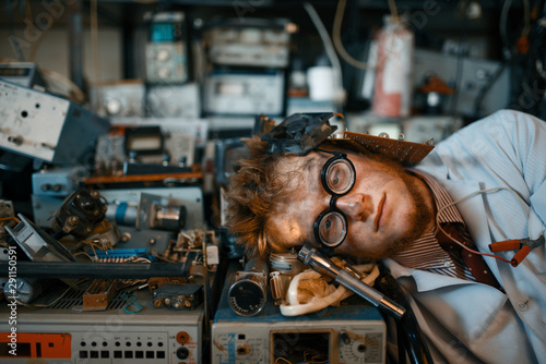 Strange engineer sleeping on devices in lab