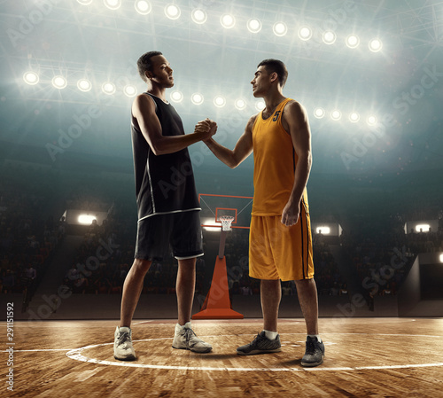 Fotografia Two professional basketball players on a basketball court shaking hands before t