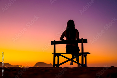 Lifestyle A girl in a beautiful sunset sitting on a chair. Copyspace