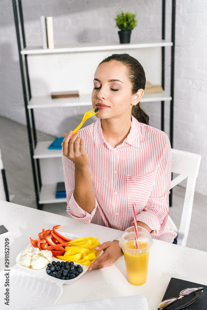 attractive woman with closed eyes holding plastic fork with paprika attractive woman with closed eyes holding plastic fork with paprika