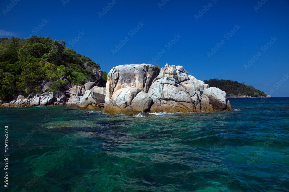 The island is located in the sea The sea is clear and can see the coral. 