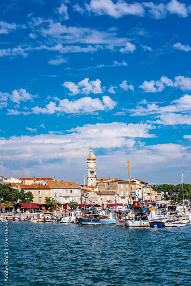 Panoramic view of Krk town with blue Adriatic Sea and boats on sunny summer day, Krk Island in Croatia