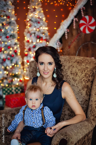 mother with child in a chair near the Christmas tree