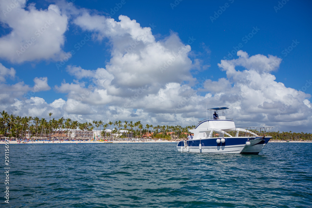 Exotic beautiful marine beach with white boat on blue water Exotic beautiful marine beach with white boat on blue water